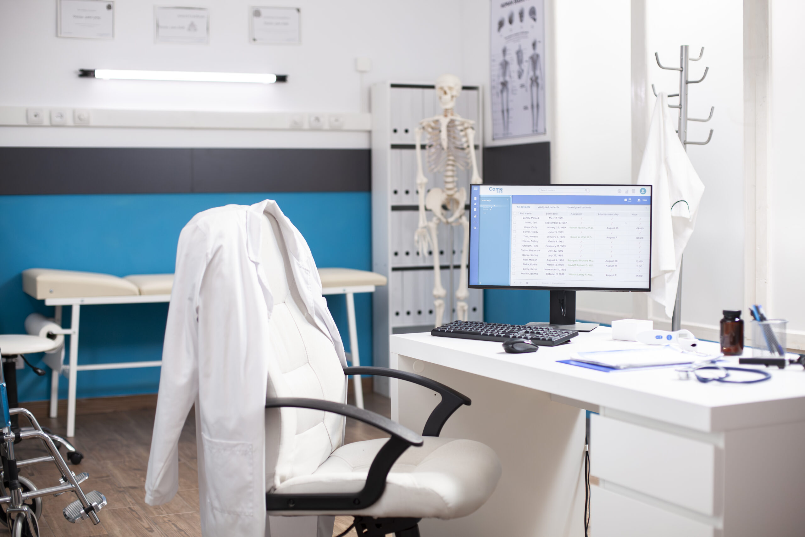 Empty medical office with no people inside, having clinical equipment and computer ready for healthcare use. Modern desktop pc in vacant hospital room displaying patient diagnostic data.